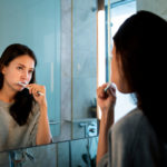 Woman Brushing Her Teeth - Absolute Smile
