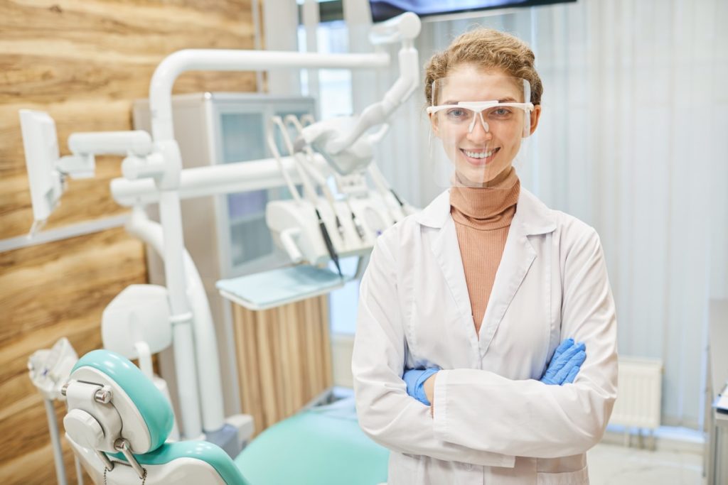 smiling dentist in modern dental clinic