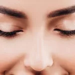 Close-up of a woman with closed eyes and smooth skin tone