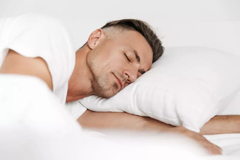 man sleeping peacefully on pillow