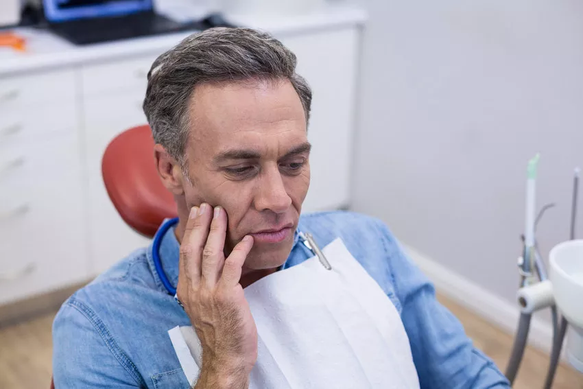 man with toothache at dentist