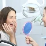 Dentist and patient smiling after successful dental checkup