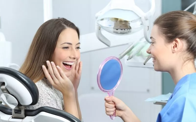 Dentist and patient smiling after successful dental checkup
