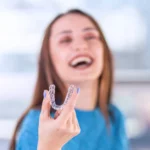 woman holding clear aligner