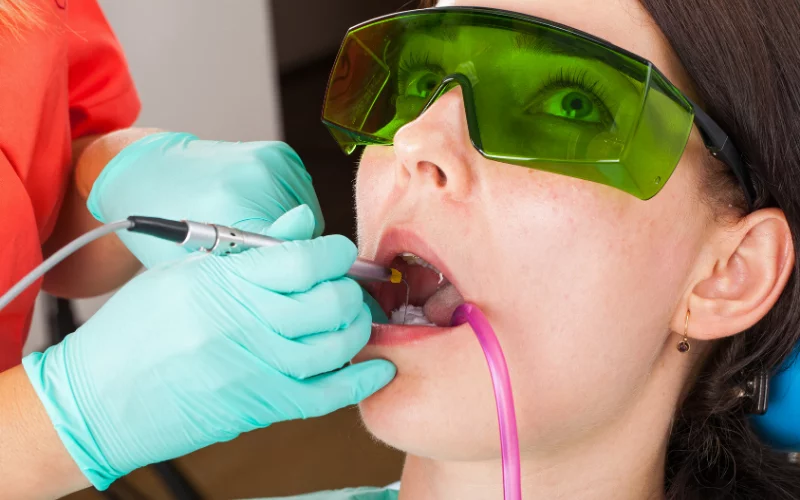 Patient receiving dental laser treatment under supervision