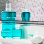 Blue mouthwash and brush set on a bathroom countertop