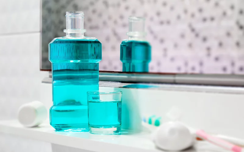Blue mouthwash and brush set on a bathroom countertop