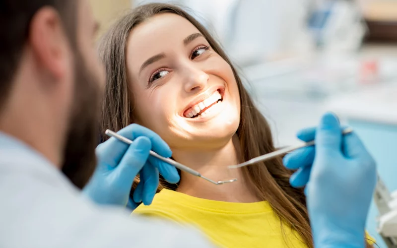 Woman smiling during a dental checkup with dentist in clinic