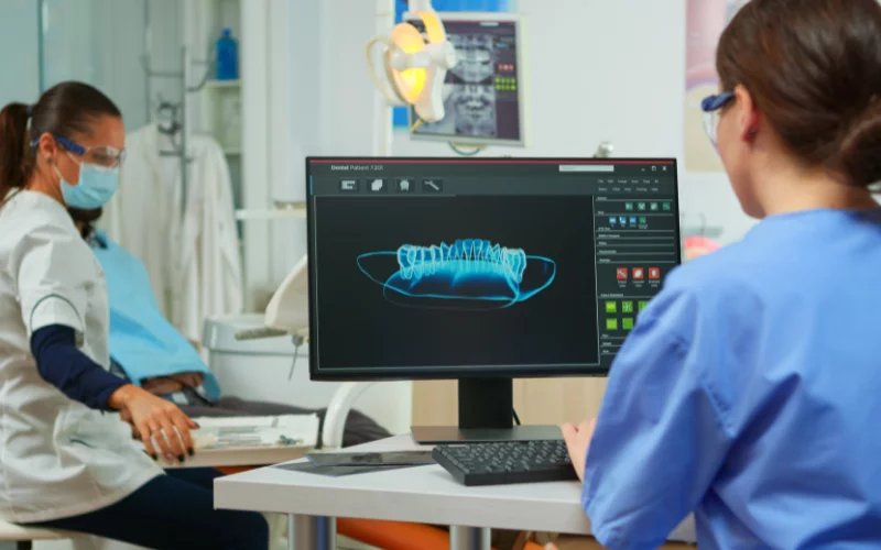 Dentist analyzing dental X-ray on computer in clinic office
