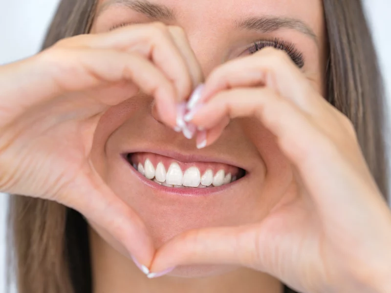 Smiling woman making a heart shape with her hands close-up