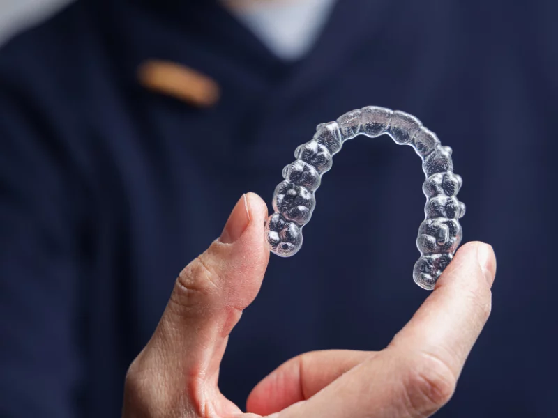 hand holding clear dental aligner